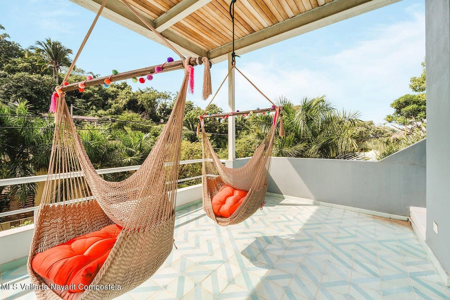 Terraza al aire libre de Casa Palmazul en Sayulita, con vistas panorámicas, muebles cómodos para relajarse, y decoración tropical, perfecta para disfrutar del sol y del entorno natural.