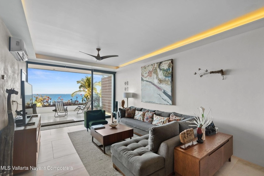 Modern living space with sliding doors to private deck and ocean views